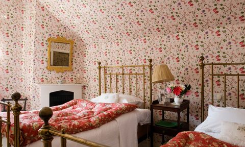 grandmillenial bedroom with two beds and patterned wallpaper