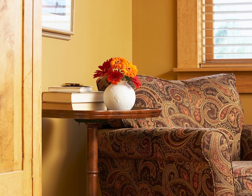 Grandmillenial vintage floral chair design alongside vase and side table