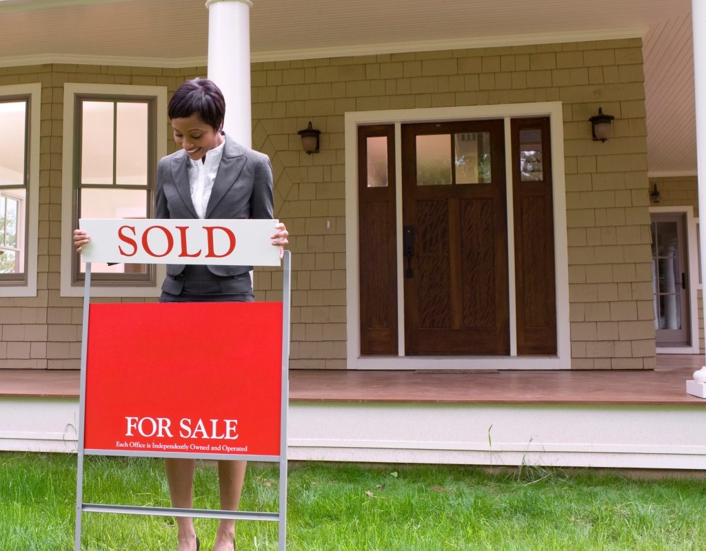 Home with for sale sign and realtor