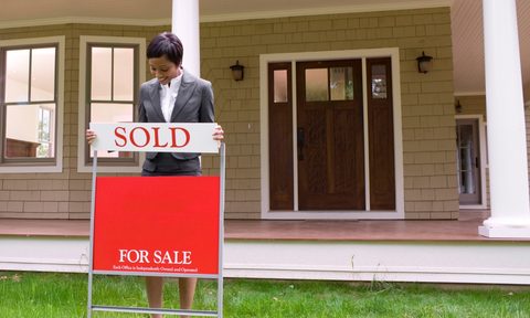 Home with for sale sign and realtor