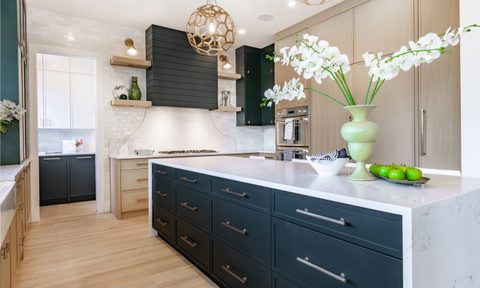 Kitchen with navy blue cabinets and bold lighting