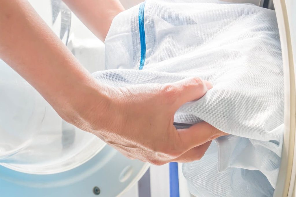 Person using laundry bag while cleaning linens