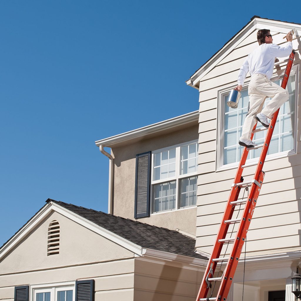 Professional painter painting a home's second story