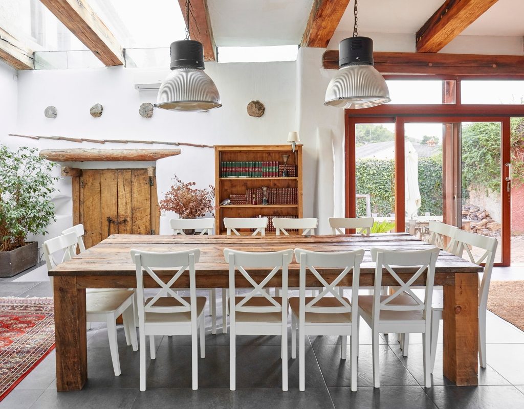 rustic mediterranean kitchen and dining area with wood table and exposed beams