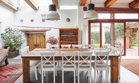 rustic mediterranean kitchen and dining area with wood table and exposed beams