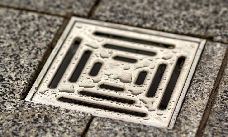 Square floor drain surrounded by tile