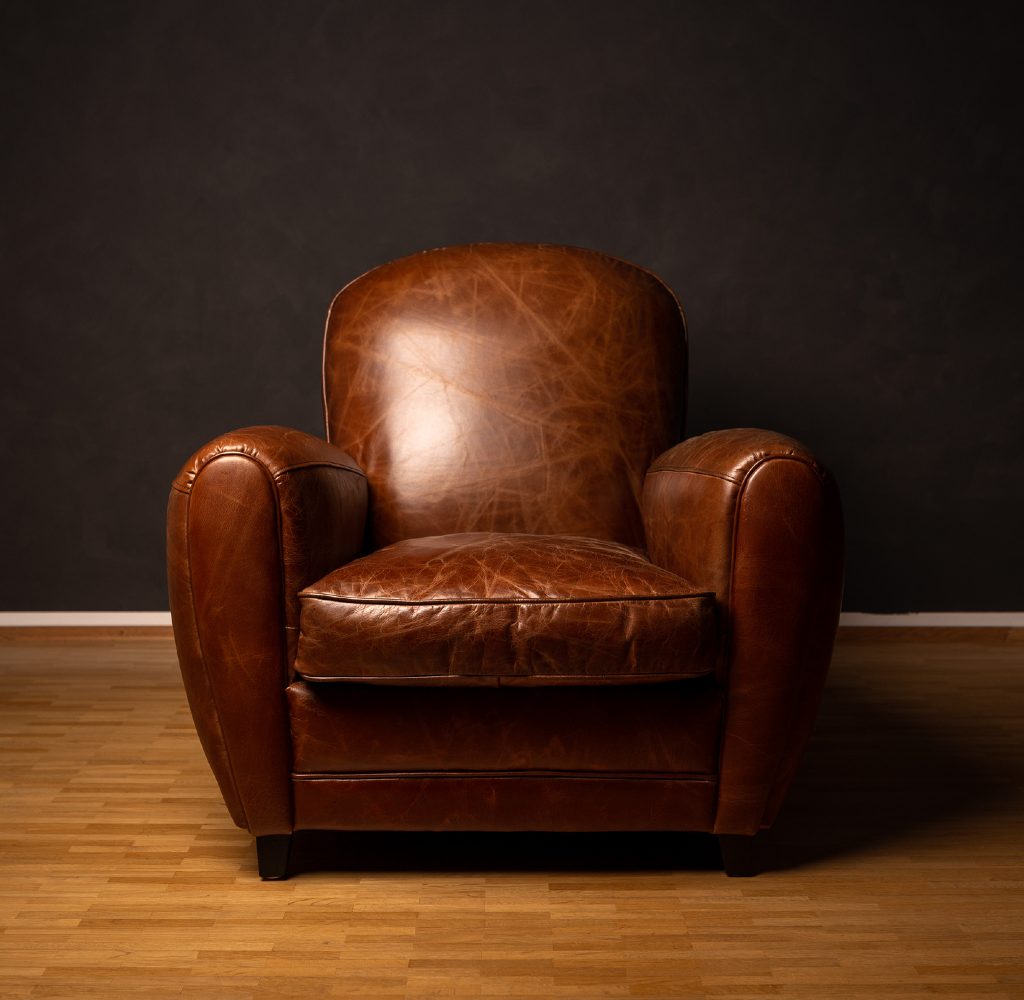 Brown armchair with black walls.