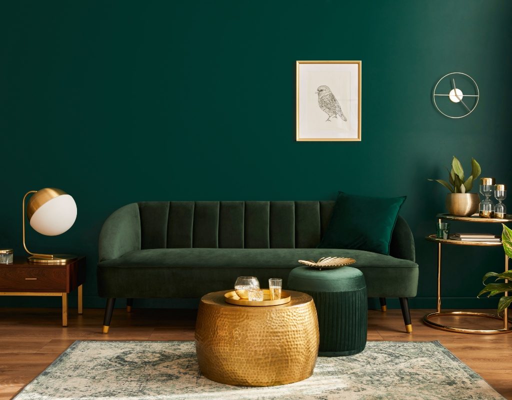 dark green living room with green sofa and gold details