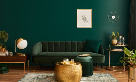 dark green living room with green sofa and gold details