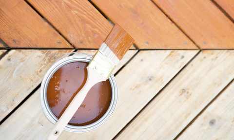 wood stain in can with brush on wood decking