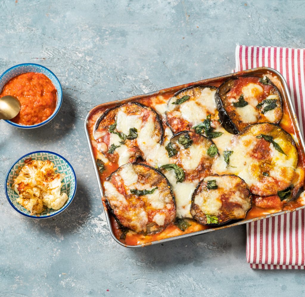Eggplant parmesan on counter with kitchen towel.