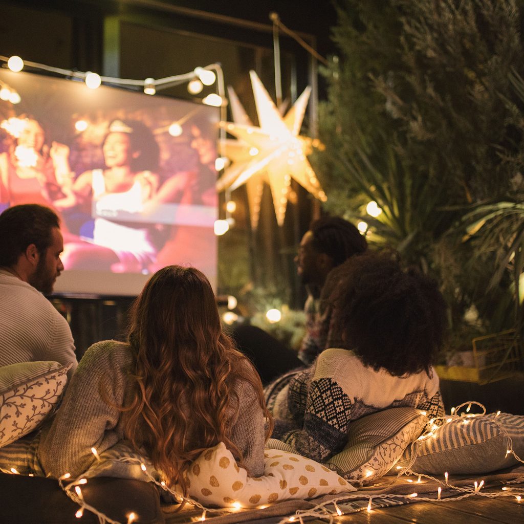 Friends watching a video outdoors using a projector
