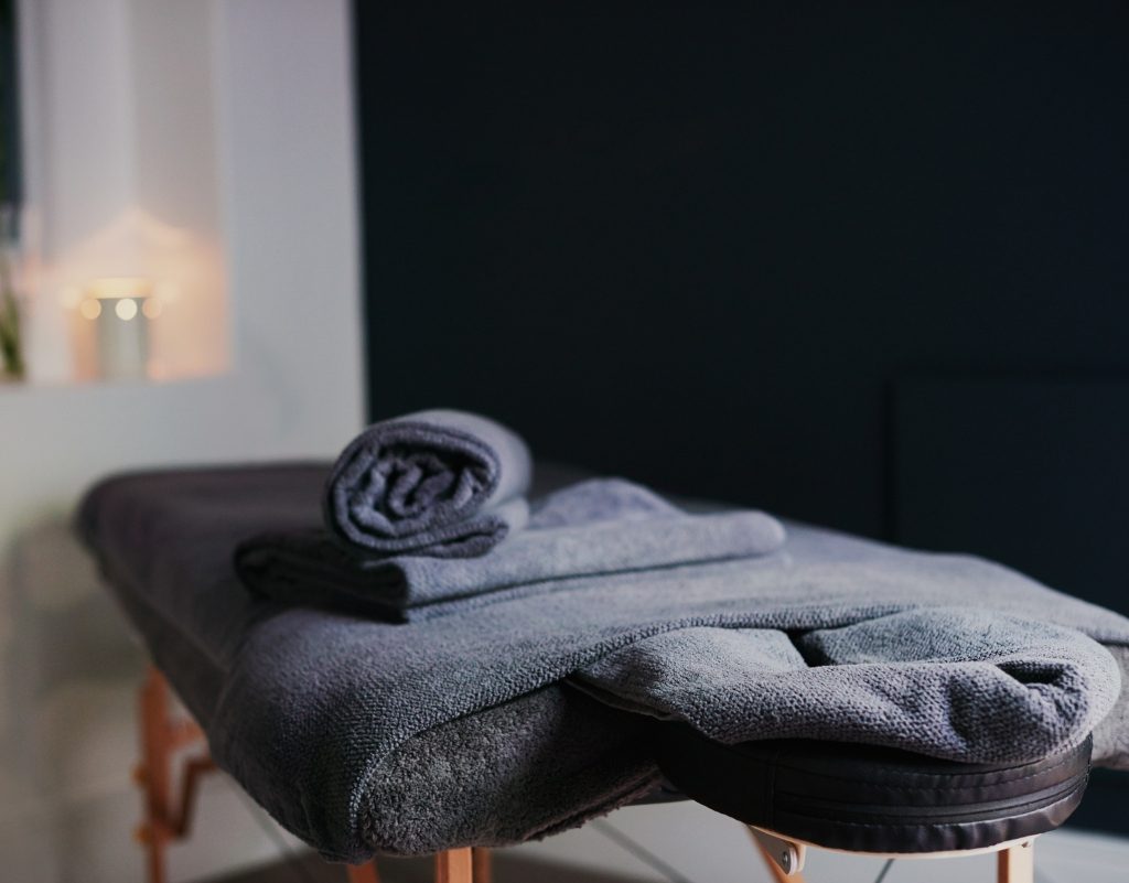 home spa massage bed with towels and candles