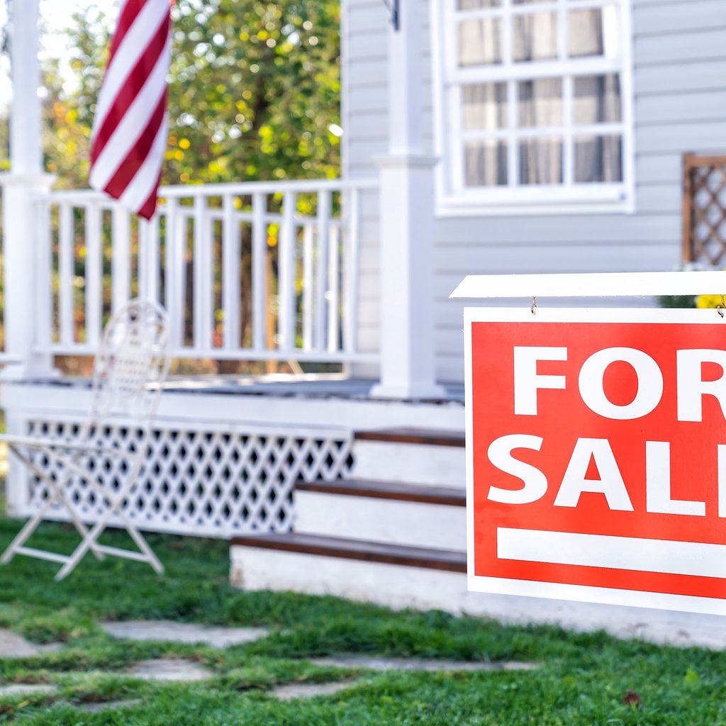 House with porch and a for sale sign