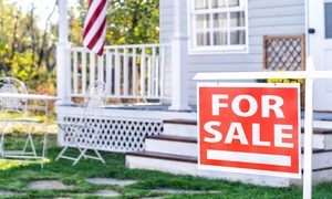 House with porch and a for sale sign