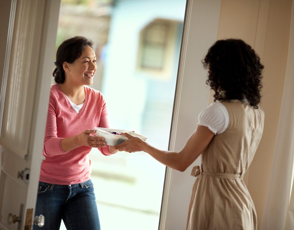 neighbor visiting homeowner with food