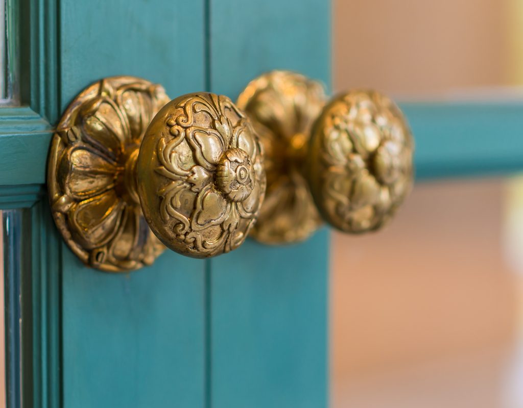 brass handles on teal cabinet doors