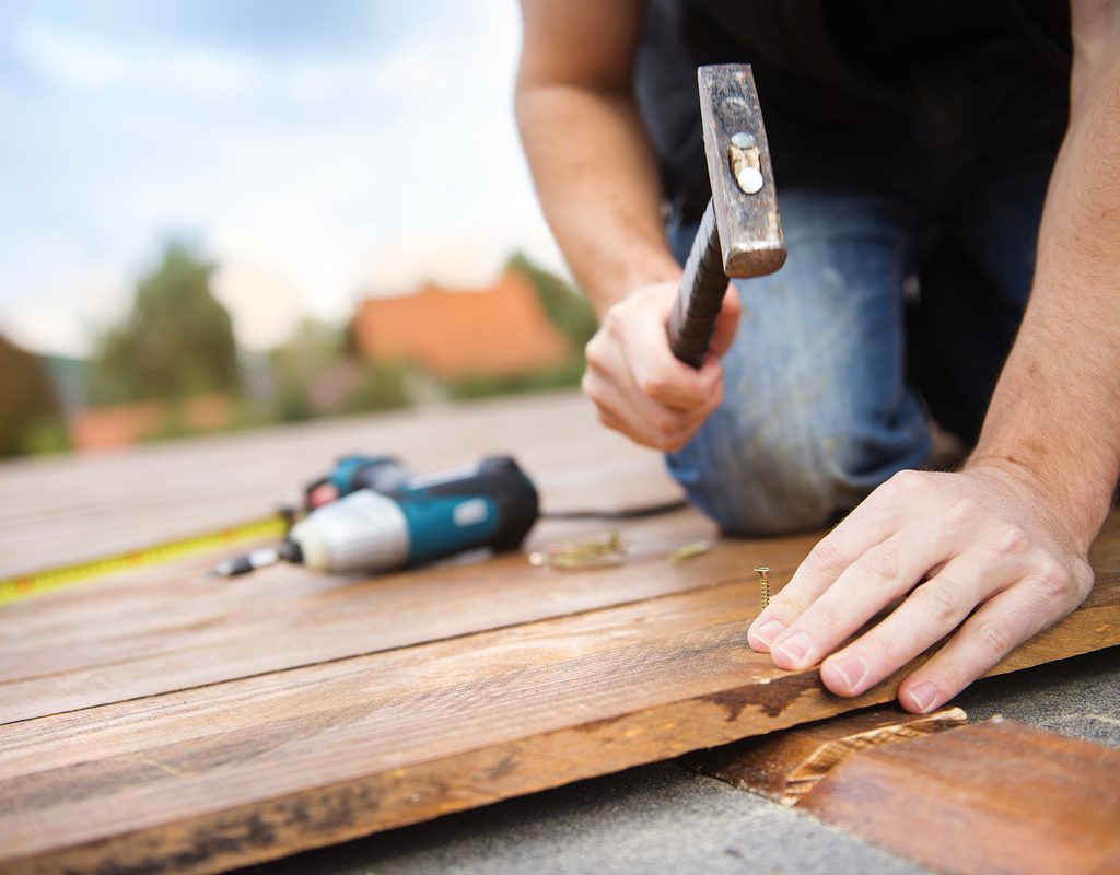 Handyman hammering wood planks