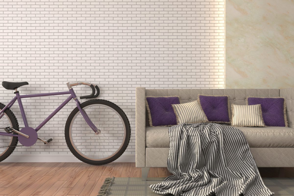 purple bike and couch against white brick wall