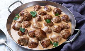 Swedish meatballs and light colored gravy in a silver pan