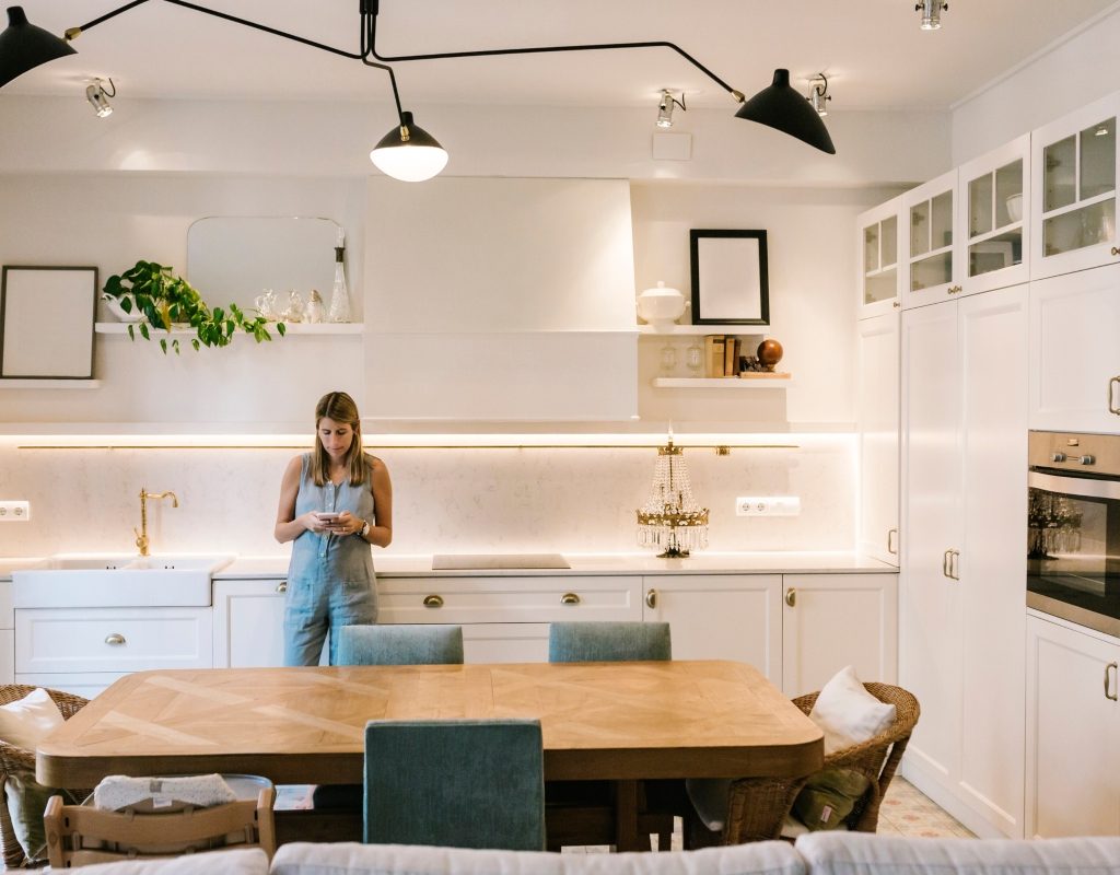 Woman standing in modern kitchen with unique light fixture