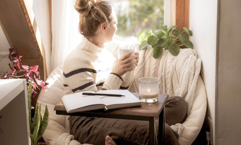 woman taking mental health break with a journal and coffee