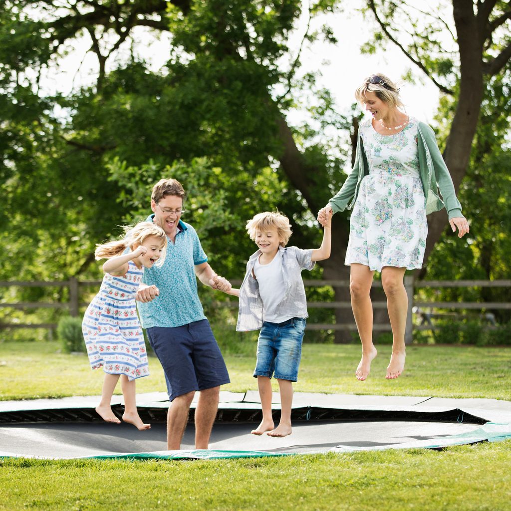 Family jumping on in-ground trampoline together
