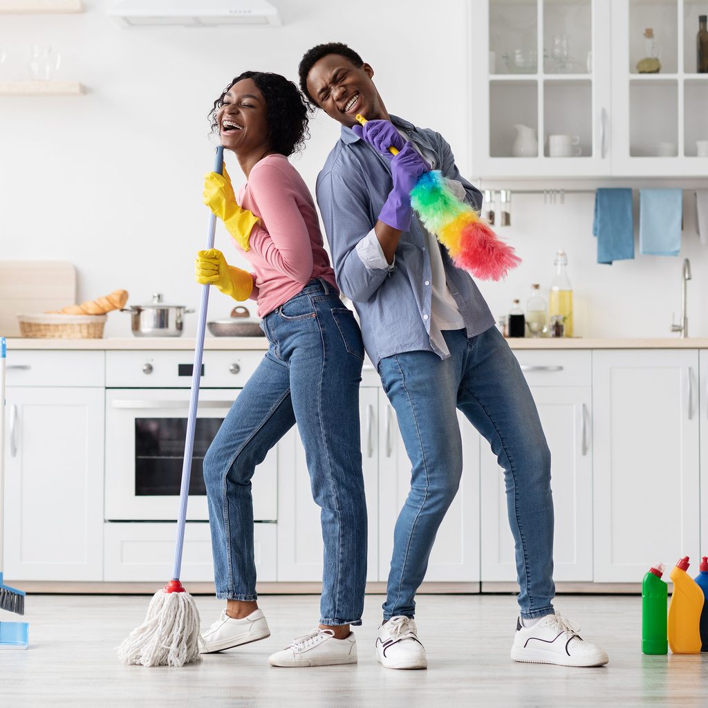 Family pretending to sing with cleaning equipment