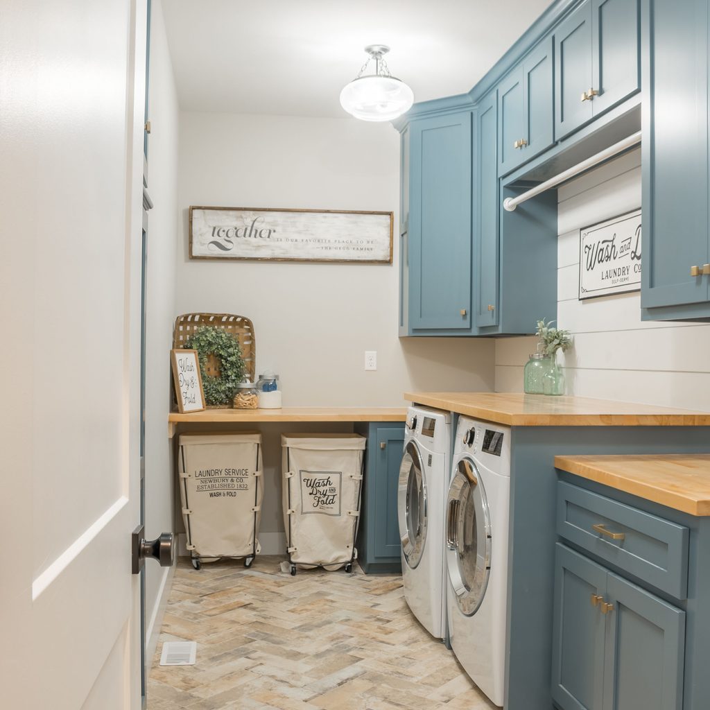 Farmhouse style laundry room with blue cabinets