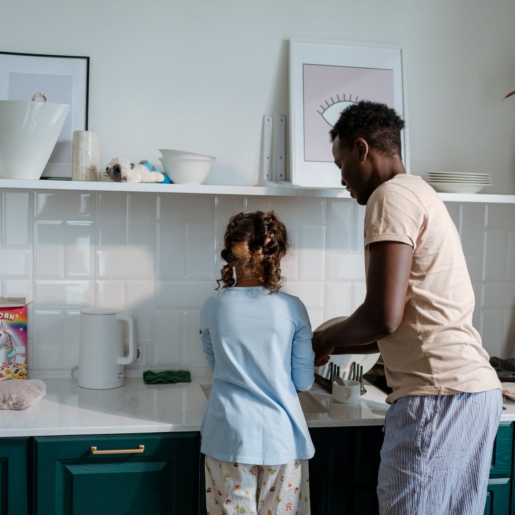 Father and daughter washing dishes together