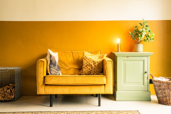 Mustard yellow room with a yellow couch and side table