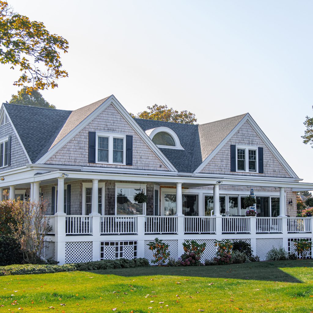 Gray house with a large yard and wraparound porch