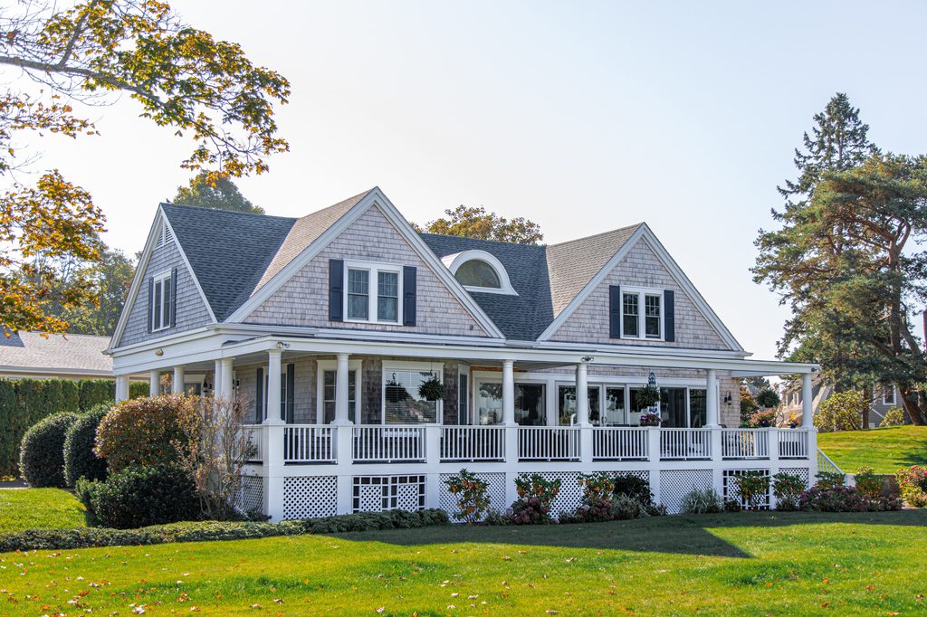 Gray house with a large yard and wraparound porch