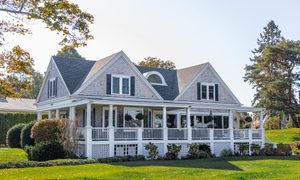 Gray house with a large yard and wraparound porch