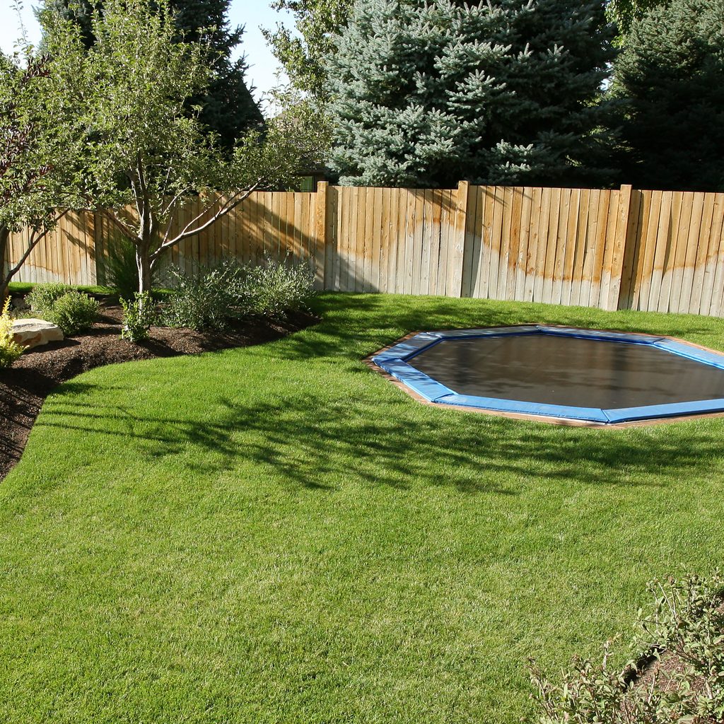 Landscaped backyard with in-ground trampoline