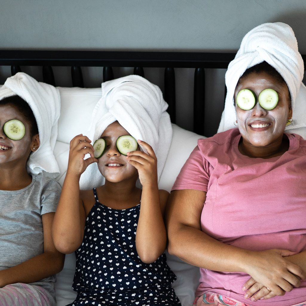 Mother and daughters in bed having a spa day