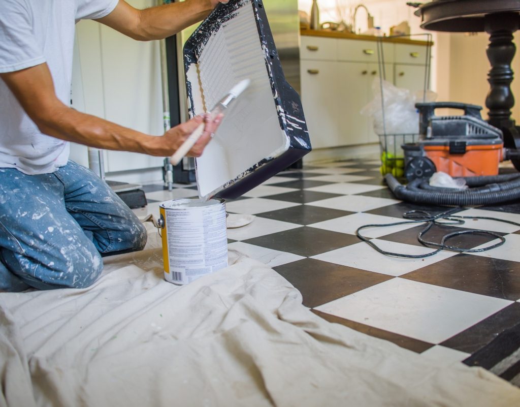 Person painting kitchen tile with DIY method