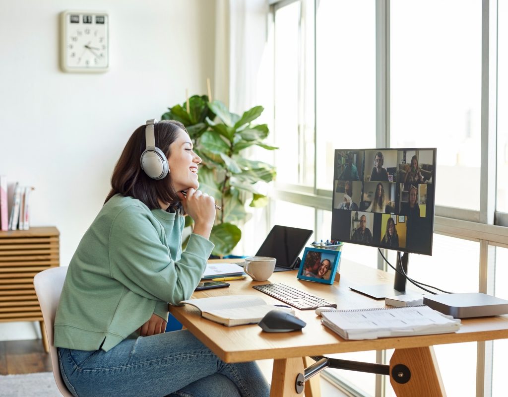 Person sitting at home office desk in front of window on computer