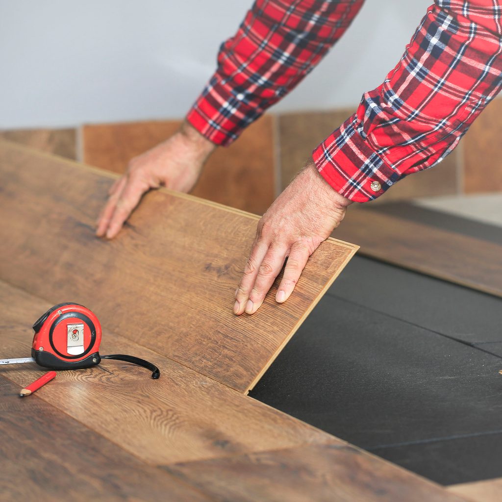 Person installing vinyl flooring planks