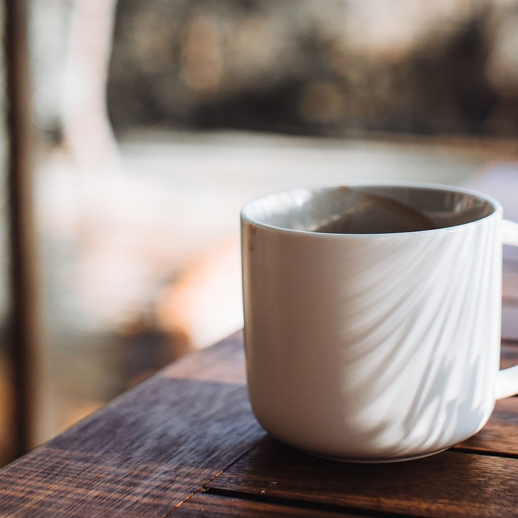 White mug full of coffee on wood table