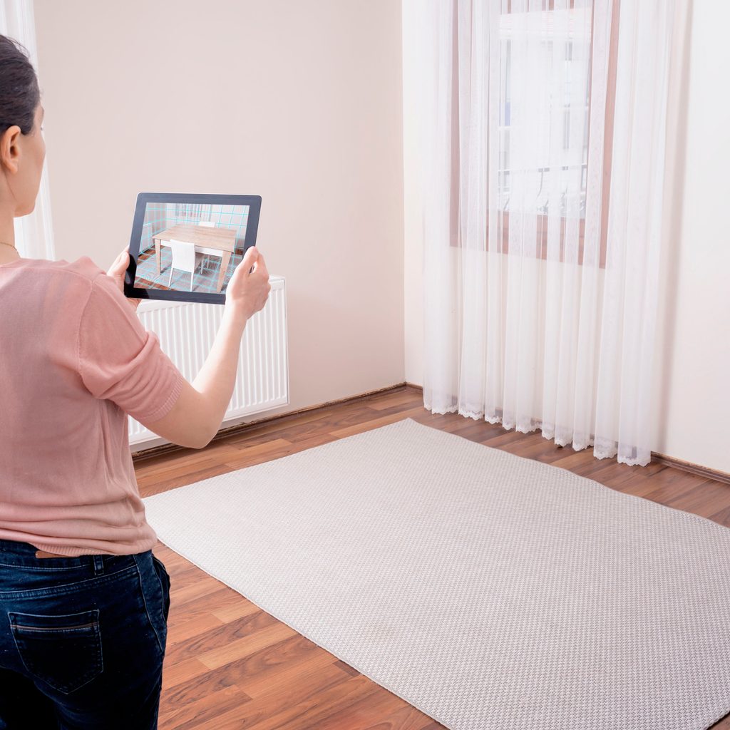 Woman using a home design app to visualize furniture in her home