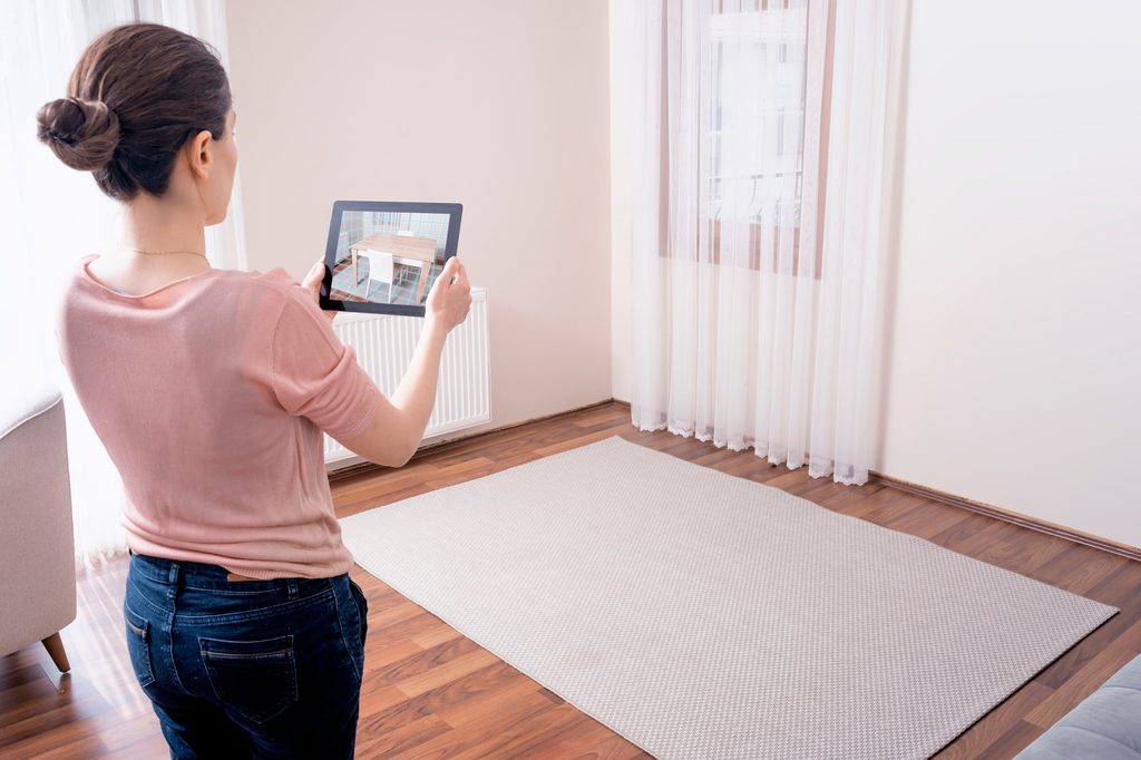 Woman using a home design app to visualize furniture in her home
