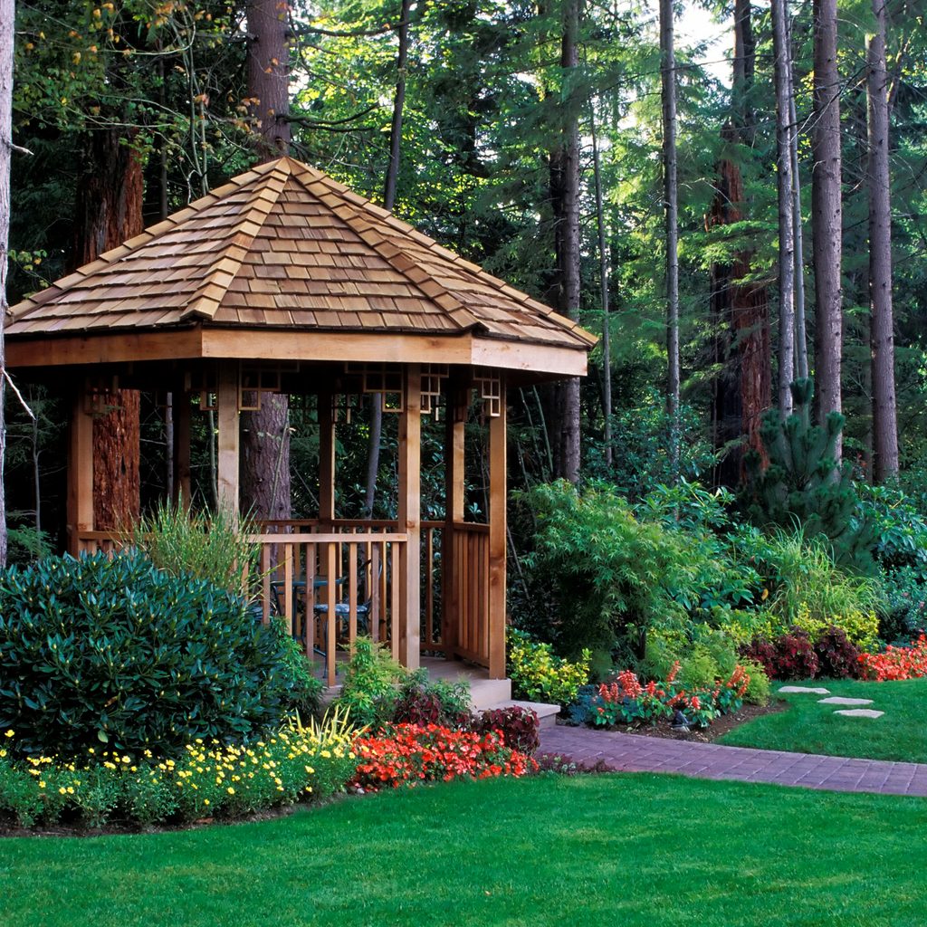Wooden gazebo surrounded by flowers and trees