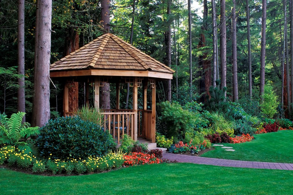 Wooden gazebo surrounded by flowers and trees