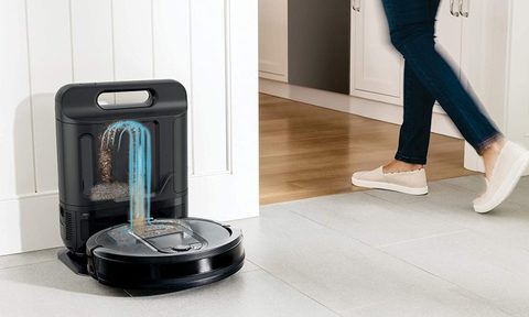 Person walking by Shark IQ self emptying robot vacuum on docking station