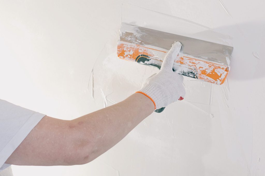 Person applying sparkle to a wall
