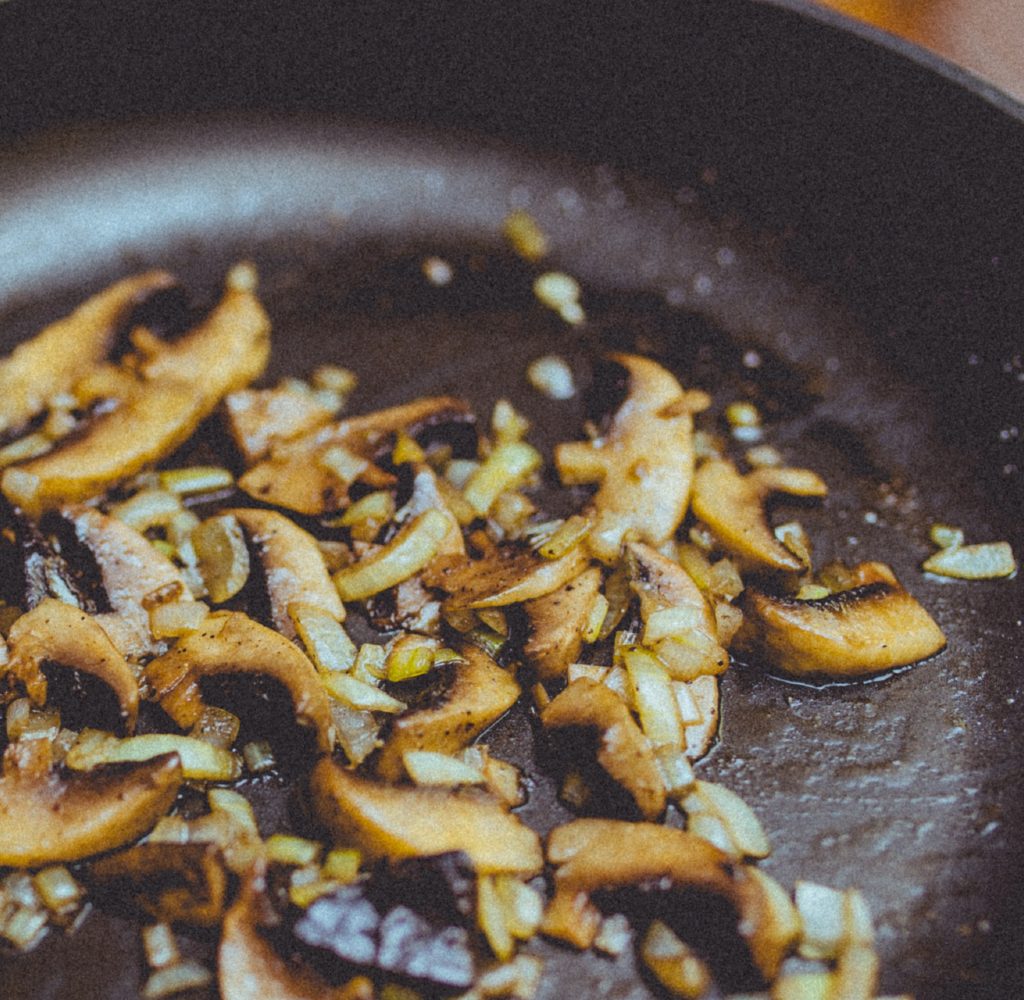 Frying pan with mushrooms and garlic cooking.