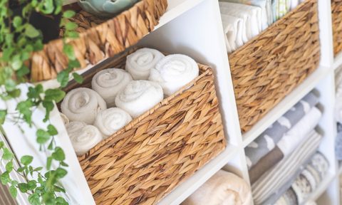 how to organize bathroom storage cabinet natural textile rolled up towels in mesh basket placed on