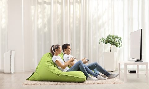 A couple playing video games in a bean bag chair