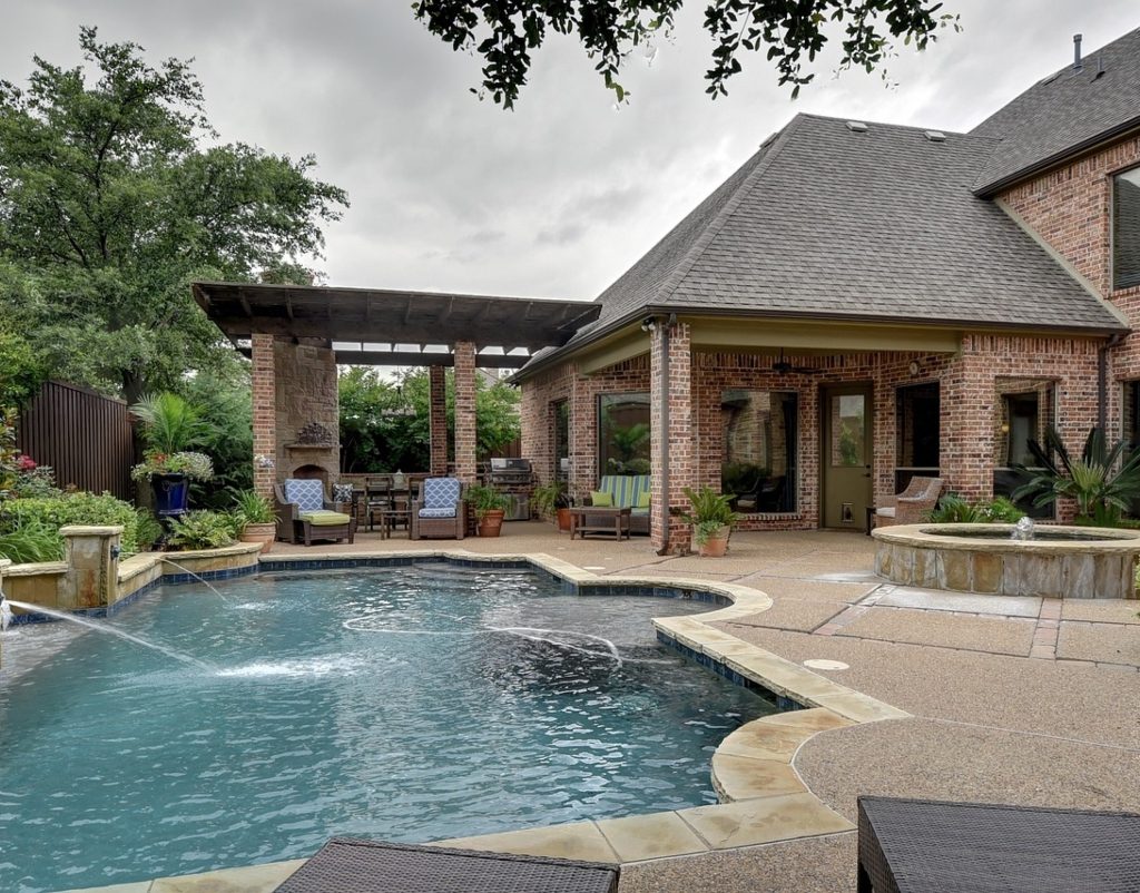 Big backyard with in-ground pool on a patio